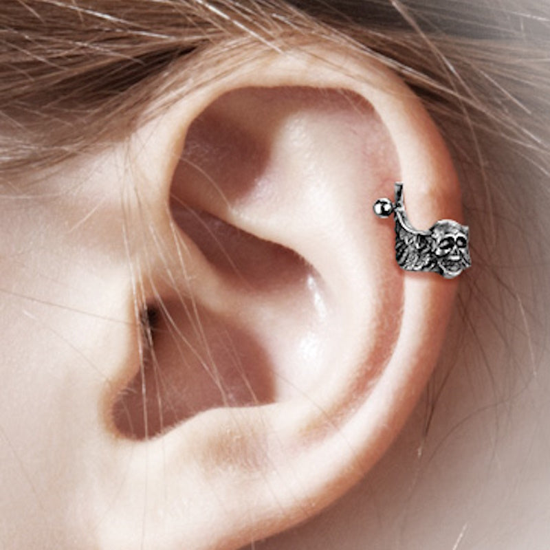 An antique silver skull helix earring cuff pictured on the ear of a model.