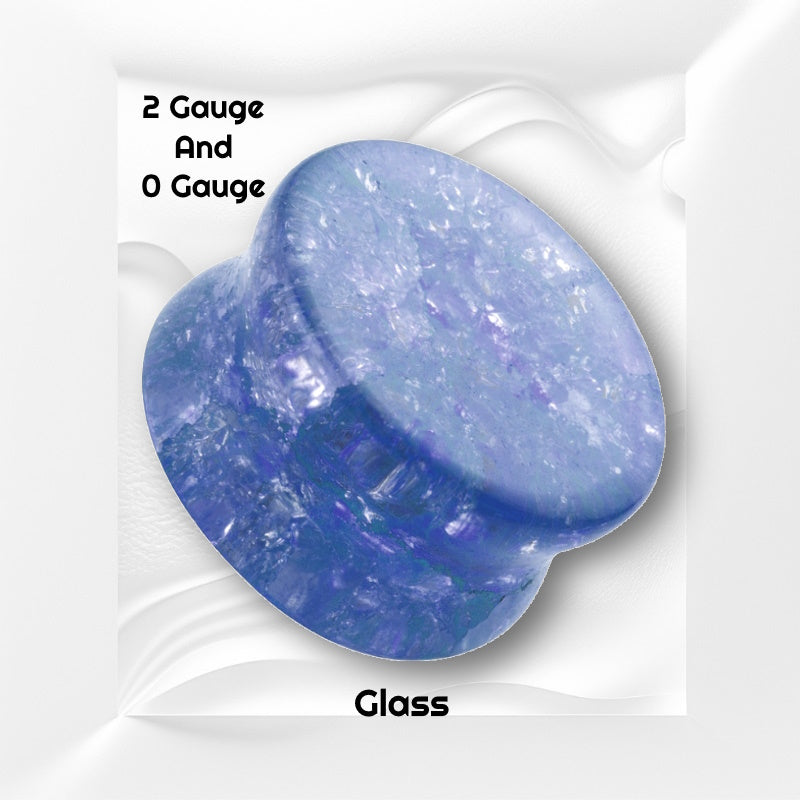 One of a pair of blue shattered glass plugs pictured on a white wavy background with black text stating the sizes available of this gauge earring.