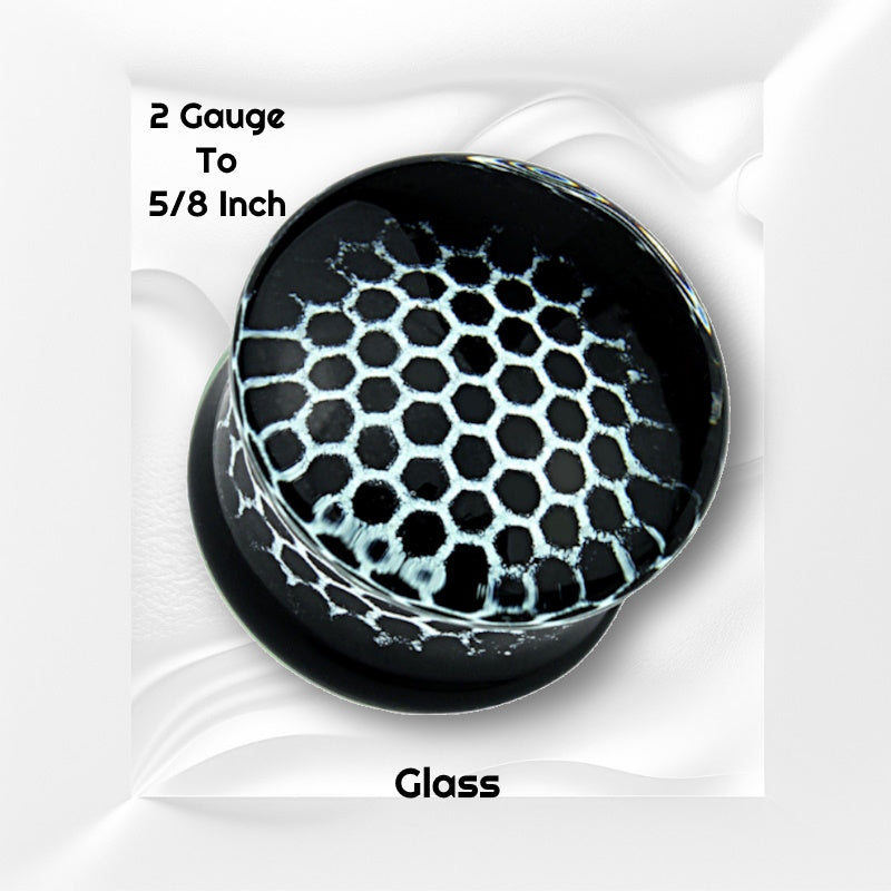 One of a pair of pyrex glass honeycomb gauges with a white honeycomb design on a black background pictured on a white wavy background with black text stating the sizes available of this gauge earring.