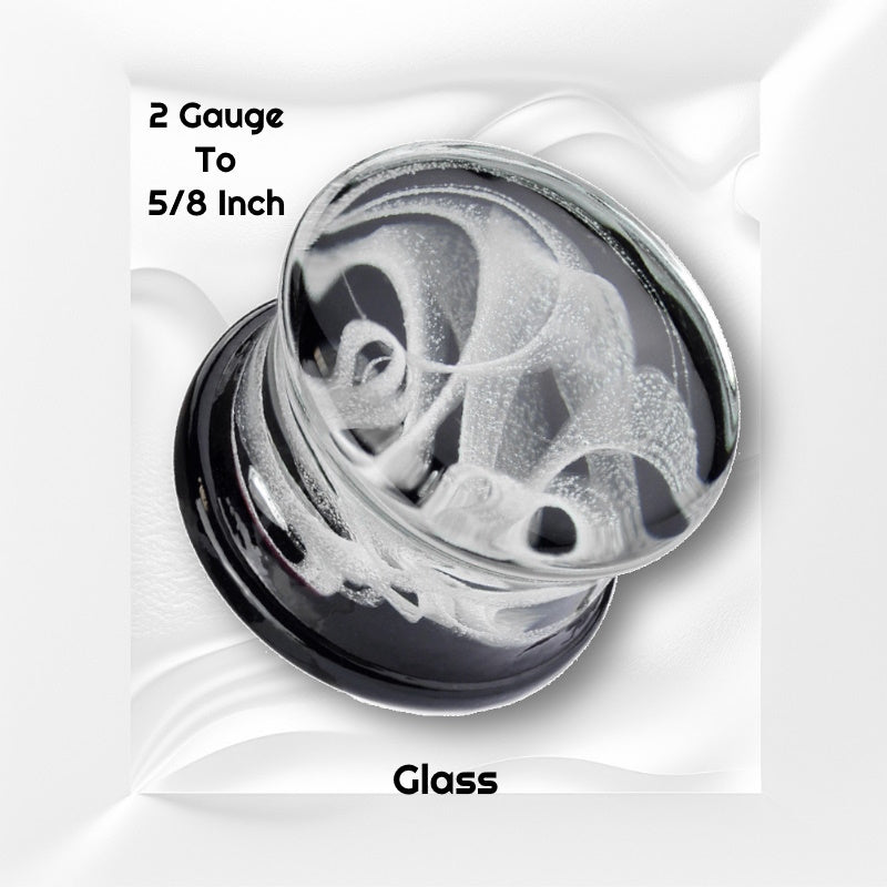 One of a pair of smoky glass ear plugs with a swirling smoke design embedded in the glass plug pictured on a white wavy background with black text stating the sizes available of this gauge earring.